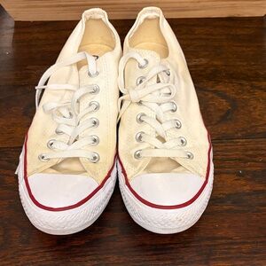 Converse Chuck Taylor All Star low-top sneakers in white canvas with red trim.